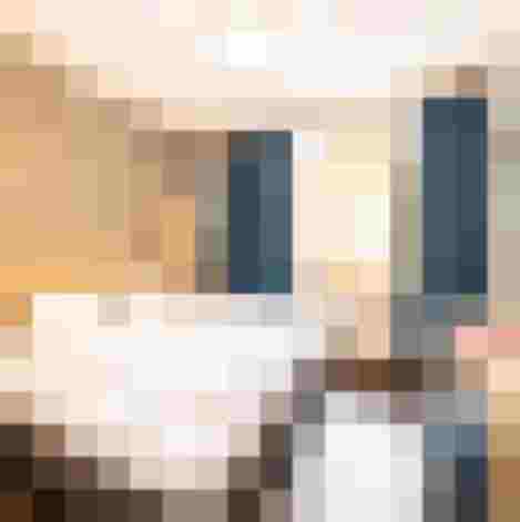 Modernes Hotelzimmer mit Doppelbett, Schreibtisch, TV und Fenster mit blauen Vorhängen