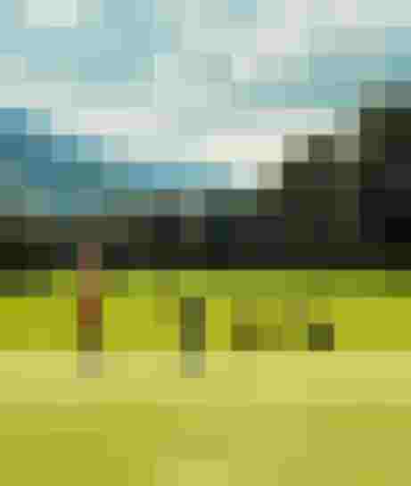 Zwei Personen spielen Golf auf grünem Platz in Berglandschaft