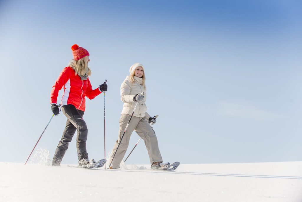 Two women snowshoeing in the snow